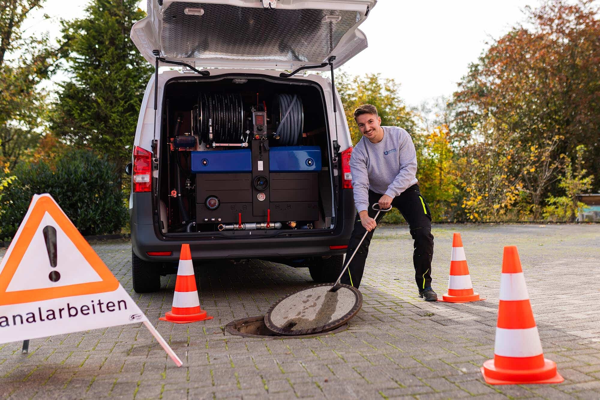 Einsatzwagen von Kanalservice Reiter mit abgesicherter Baustelle am Kanalschacht