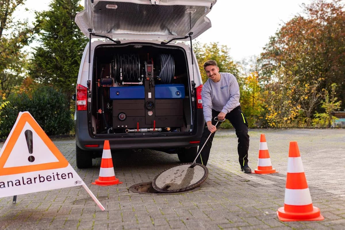 Einsatzwagen mit abgesicherter Baustelle am Kanalschacht